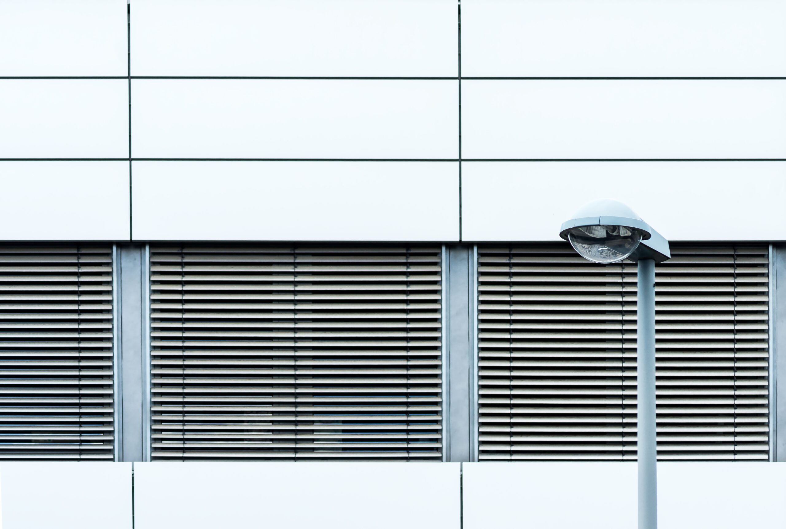 horizontal shot of a modern building's exterior with shutters, from outdoors