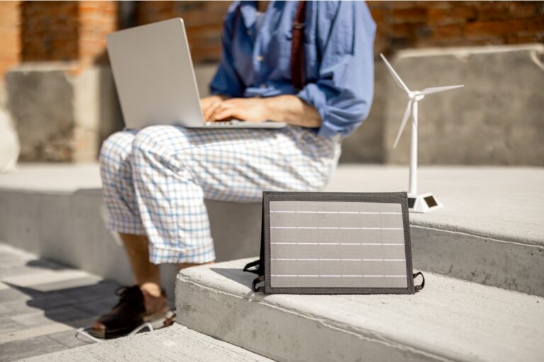 man works and charges laptop from portable solar p 2022 06 15 22 24 19 utc