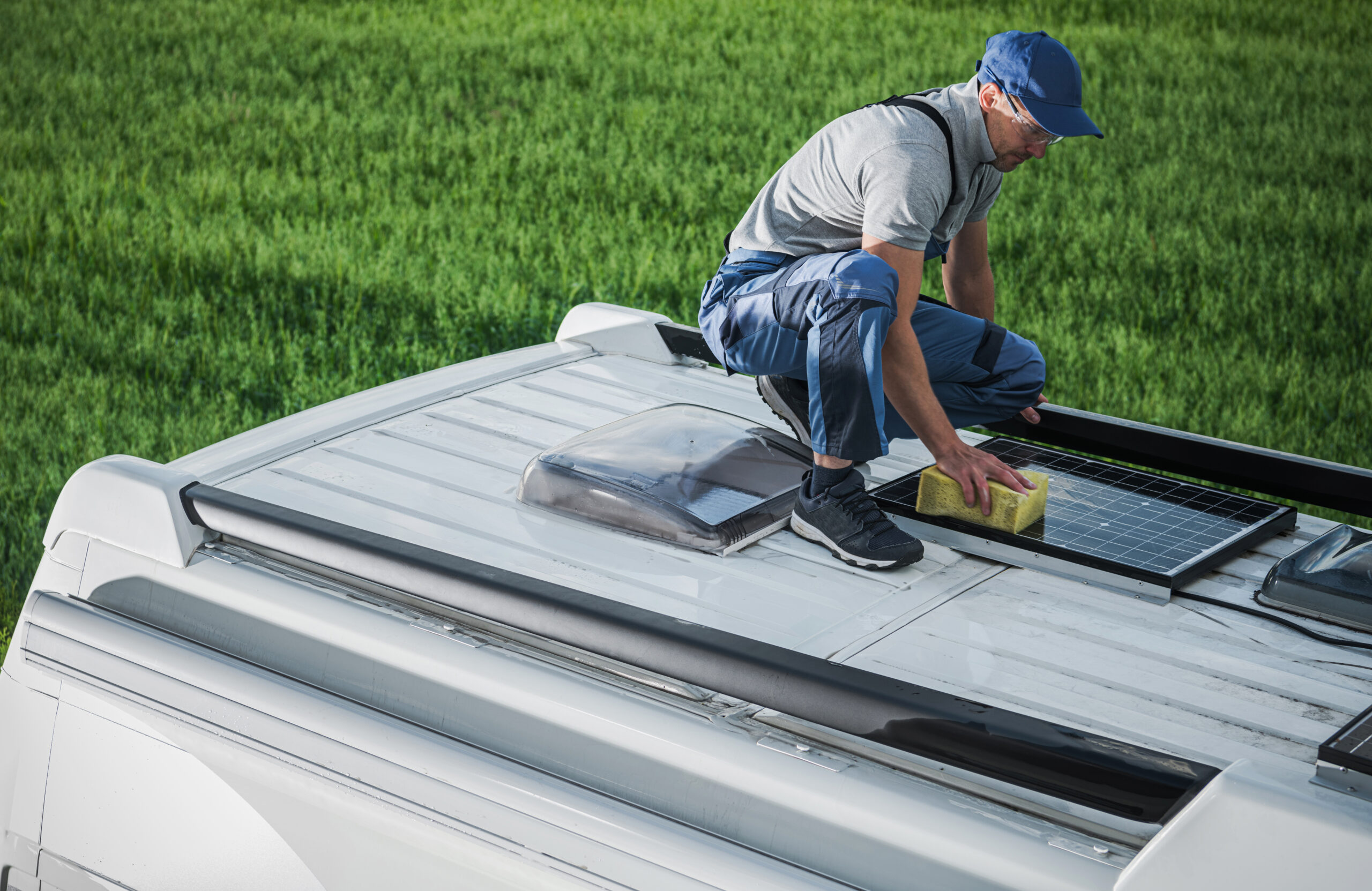 men cleaning camper van rv roof installed solar panels