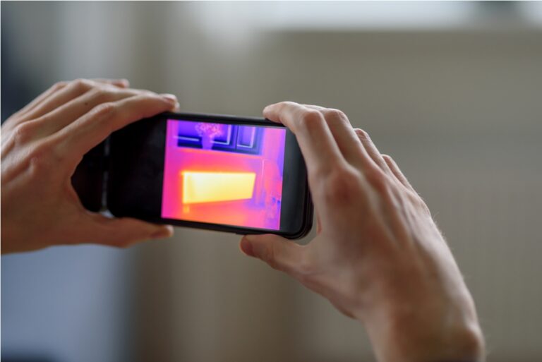 person doing thermal scanning of apartment