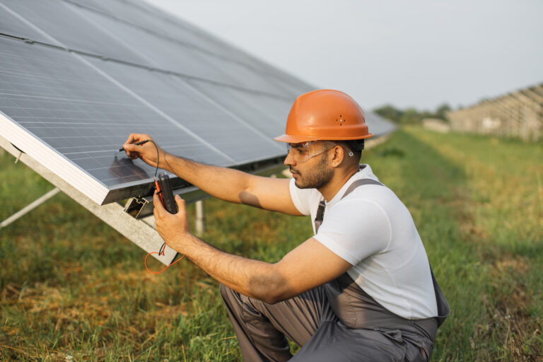 technician measuring amperage of solar panels