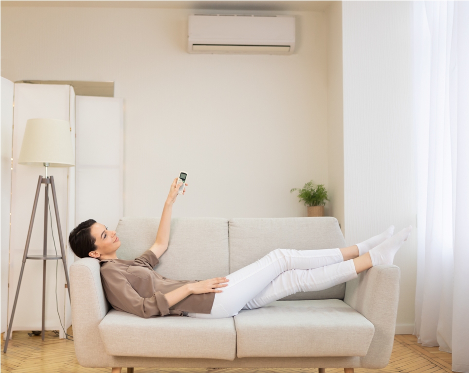 young woman switching on air conditioning at her h 2023 11 27 05 28 48 utc