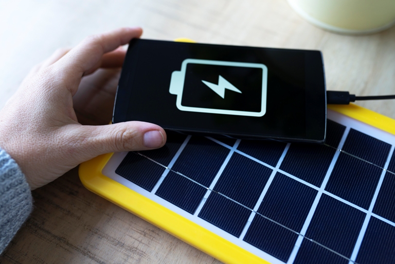 renewable energy technology, solar panel charging a mobile phone battery