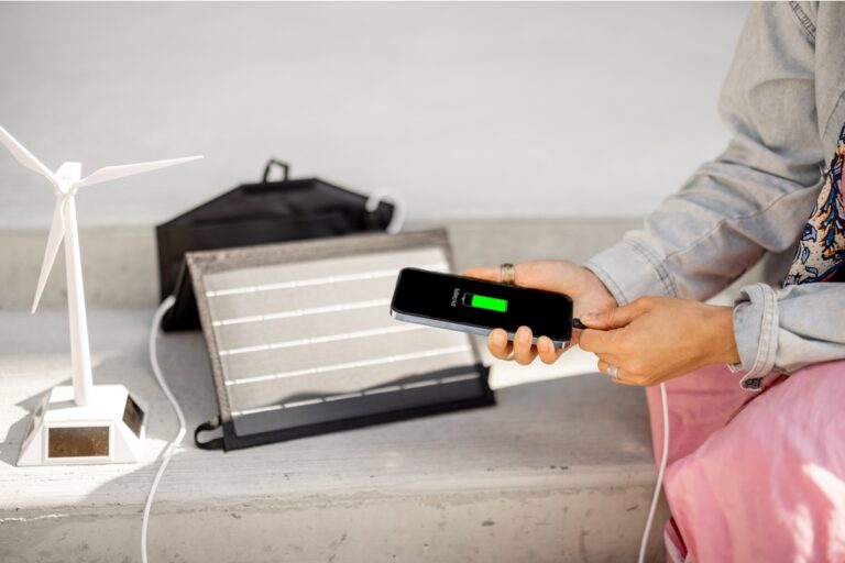 woman charge phone from a portable solar panel 2022 06 15 22 32 33 utc