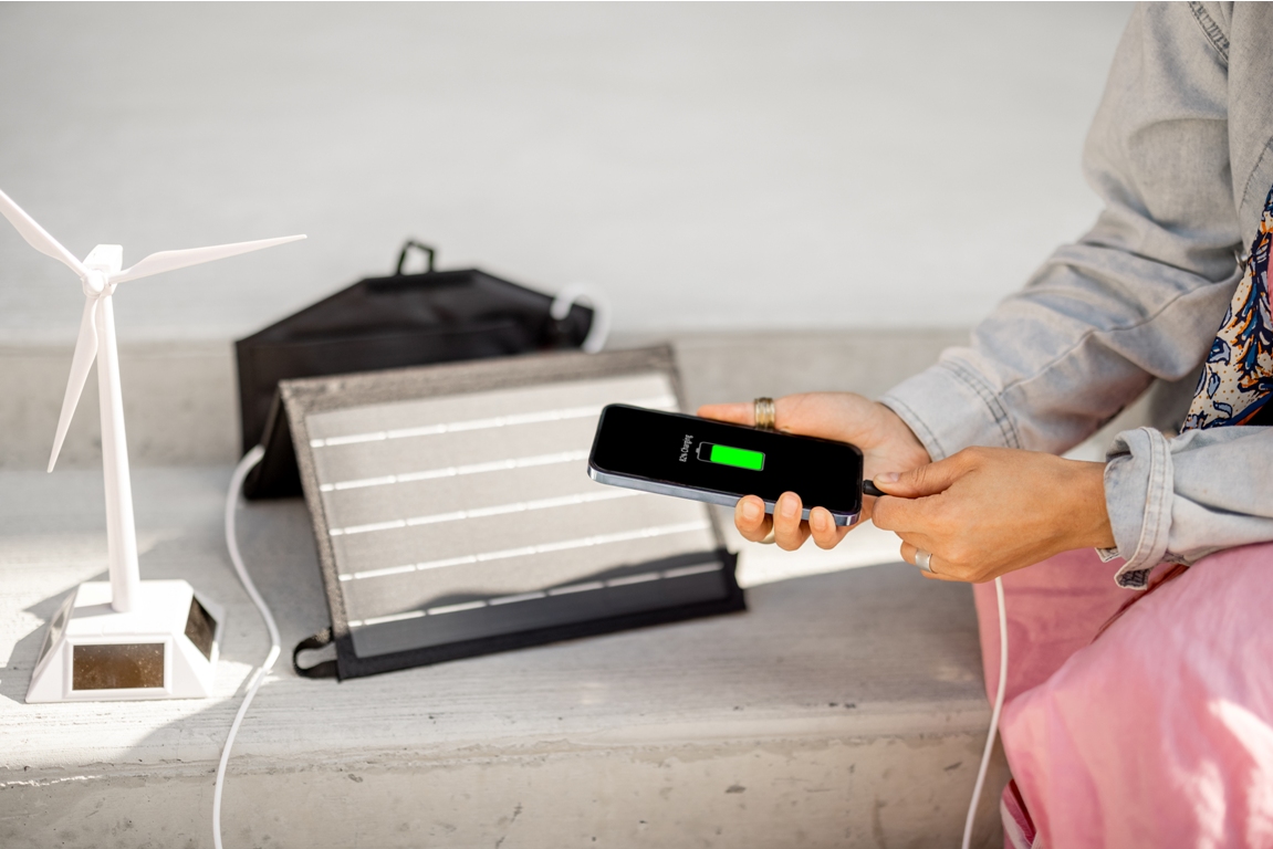 woman charge phone from a portable solar panel 2022 06 15 22 32 33 utc