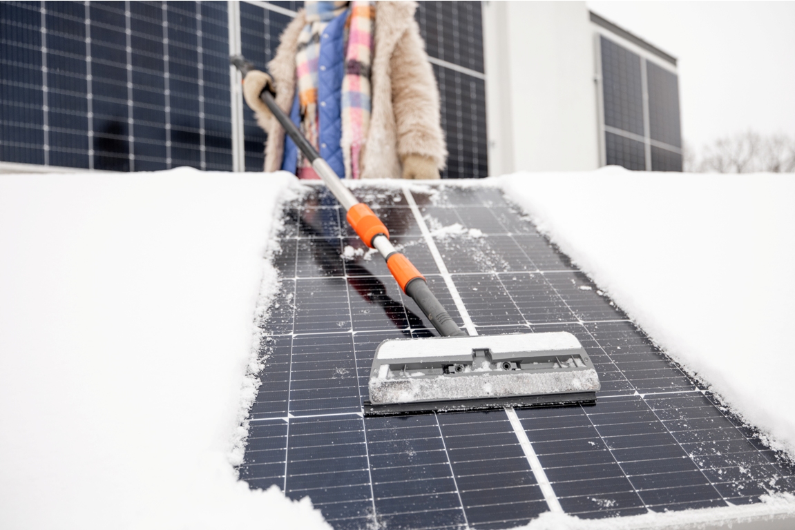 woman cleans solar panels from snow 2022 11 28 18 33 57 utc